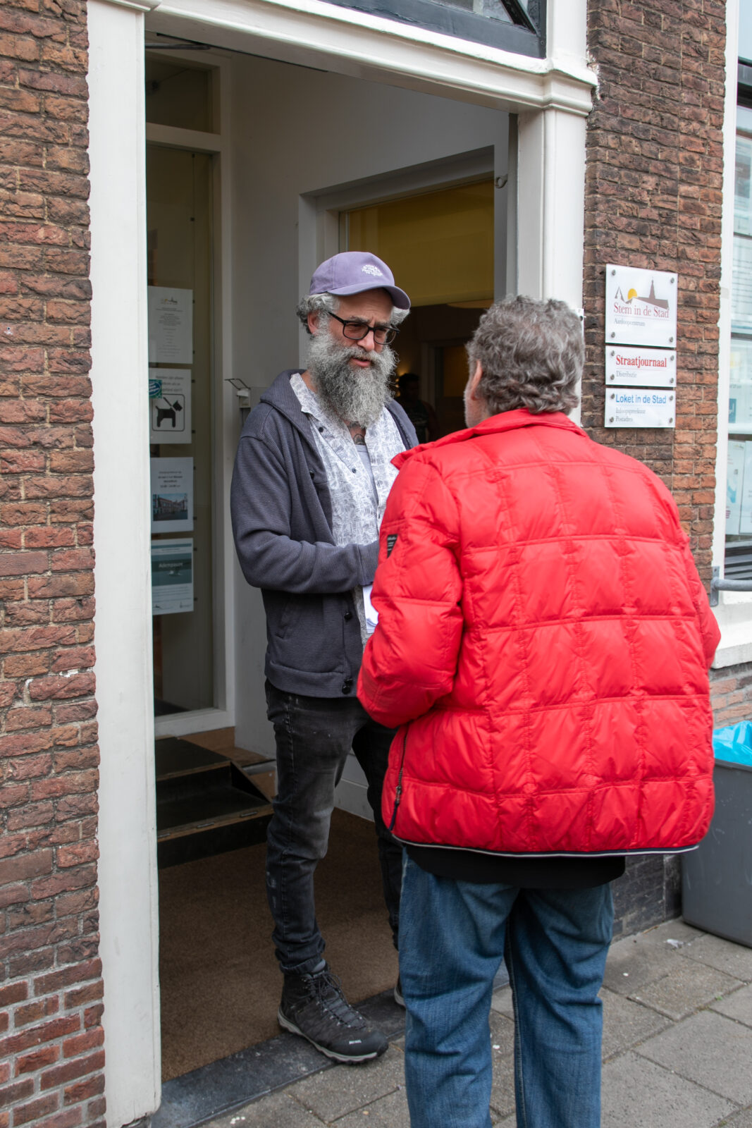 Coörindator Joshua van de Eetvoorziening bij de voordeur van Stem in de Stad.